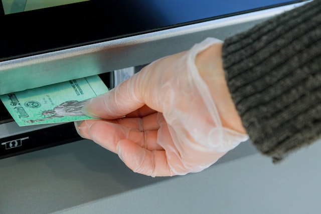 person entering deposit into atm